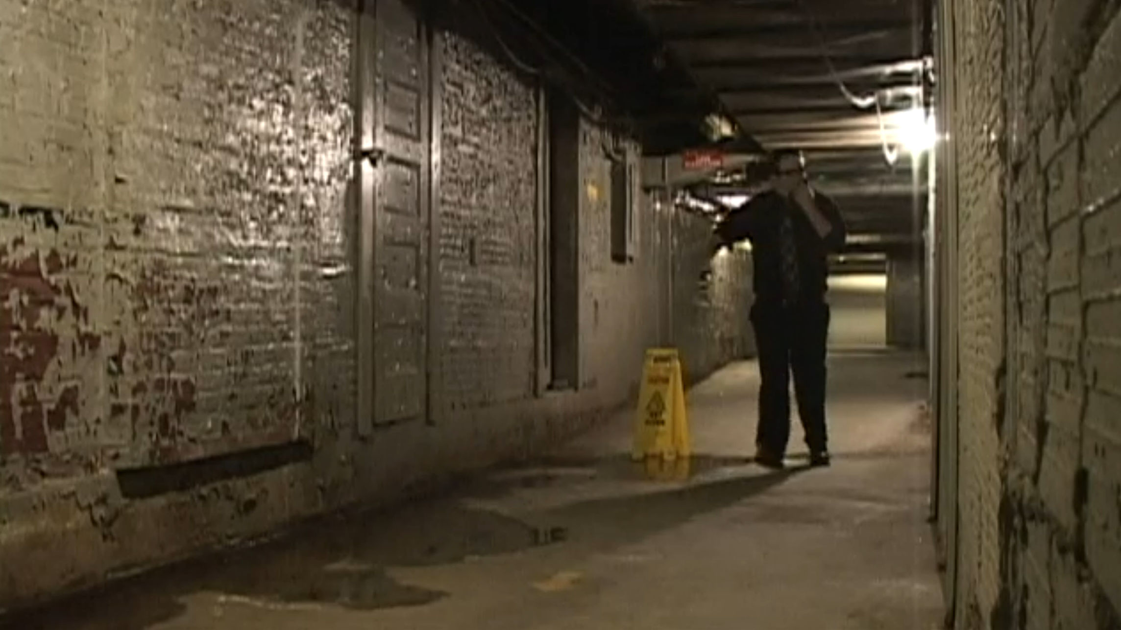 A dark hallway with a warning placard. How considerate.