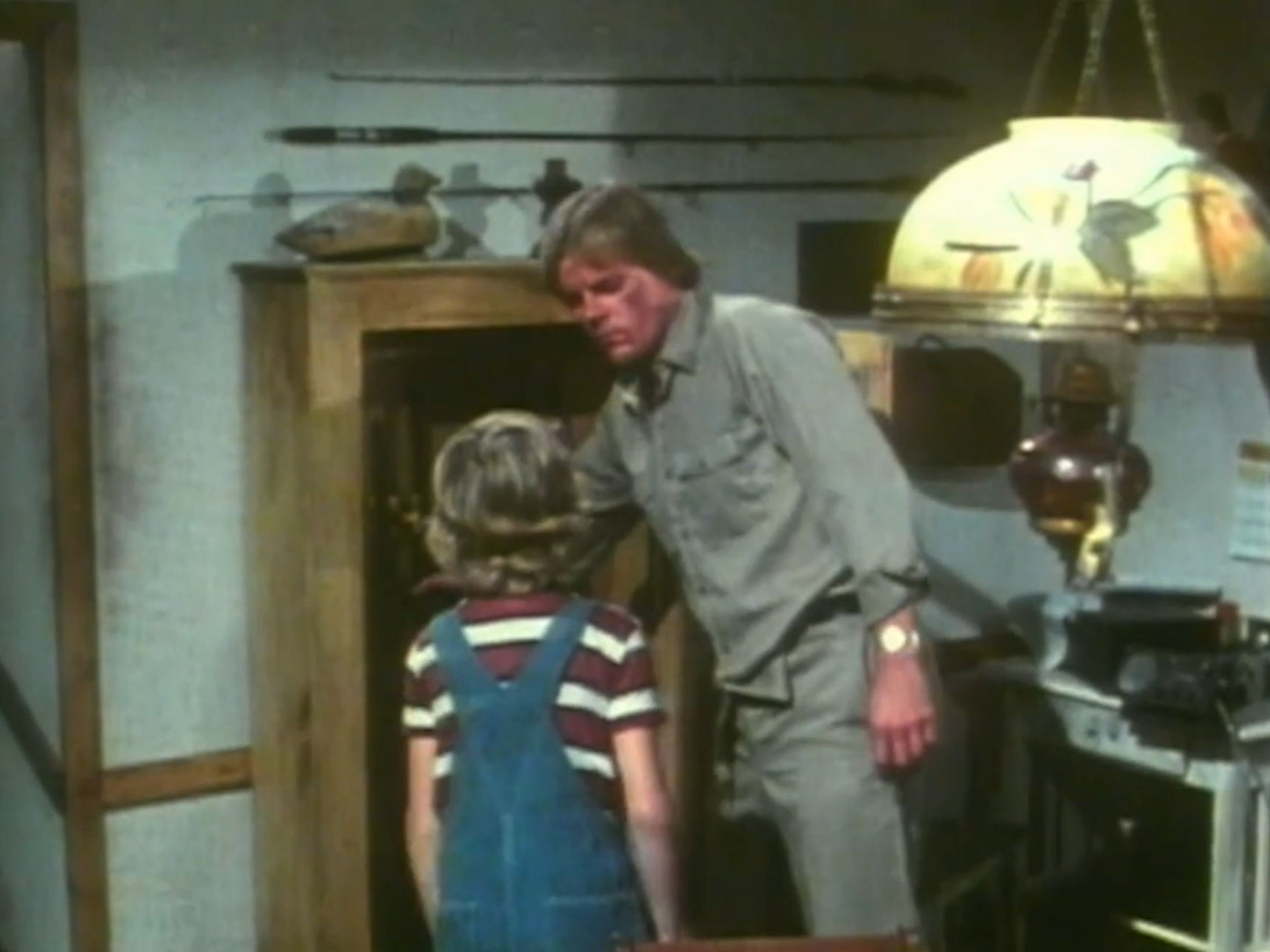 Kelly's father looks at him disapprovingly 