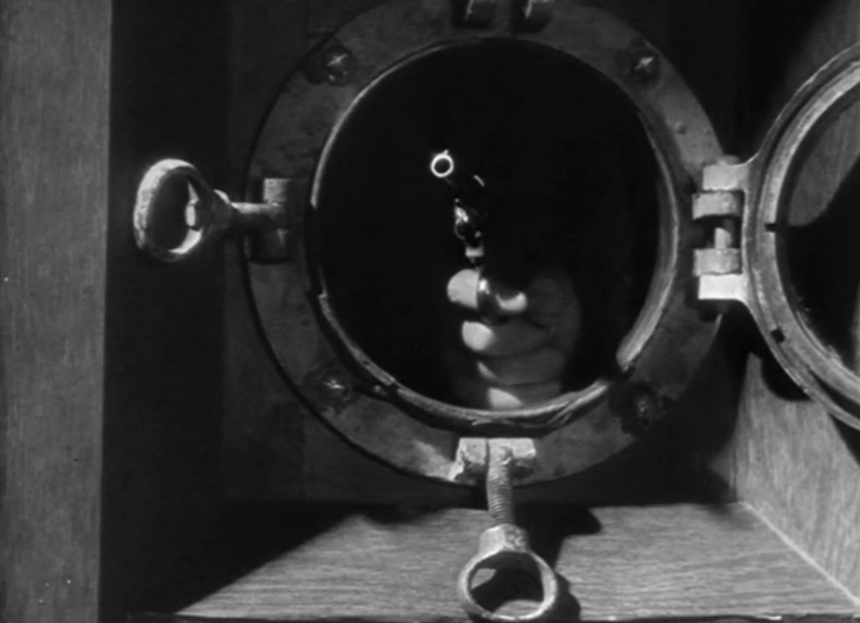 A gun being aimed through a porthole