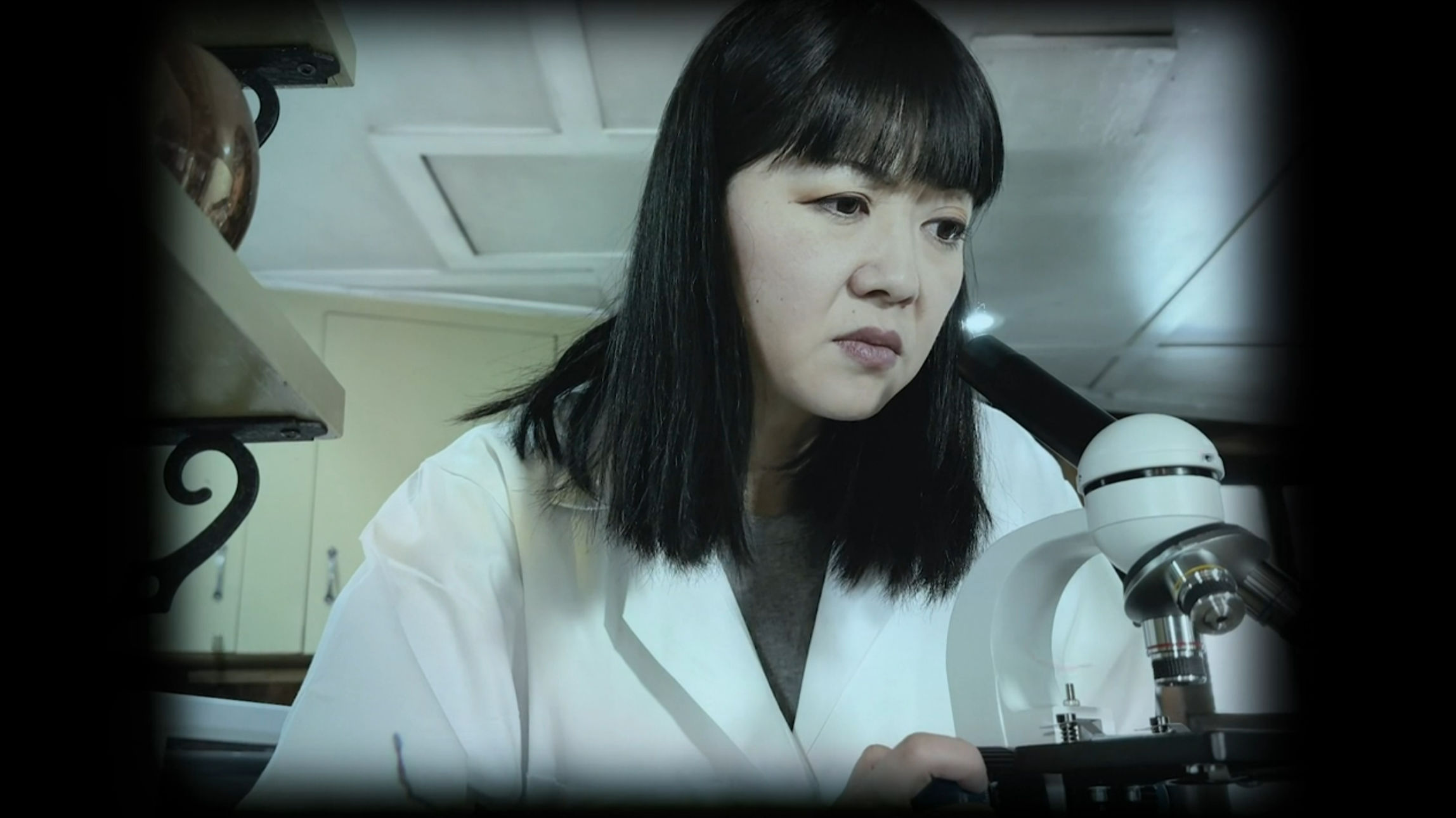 Mrs. Sato looking through a microscope