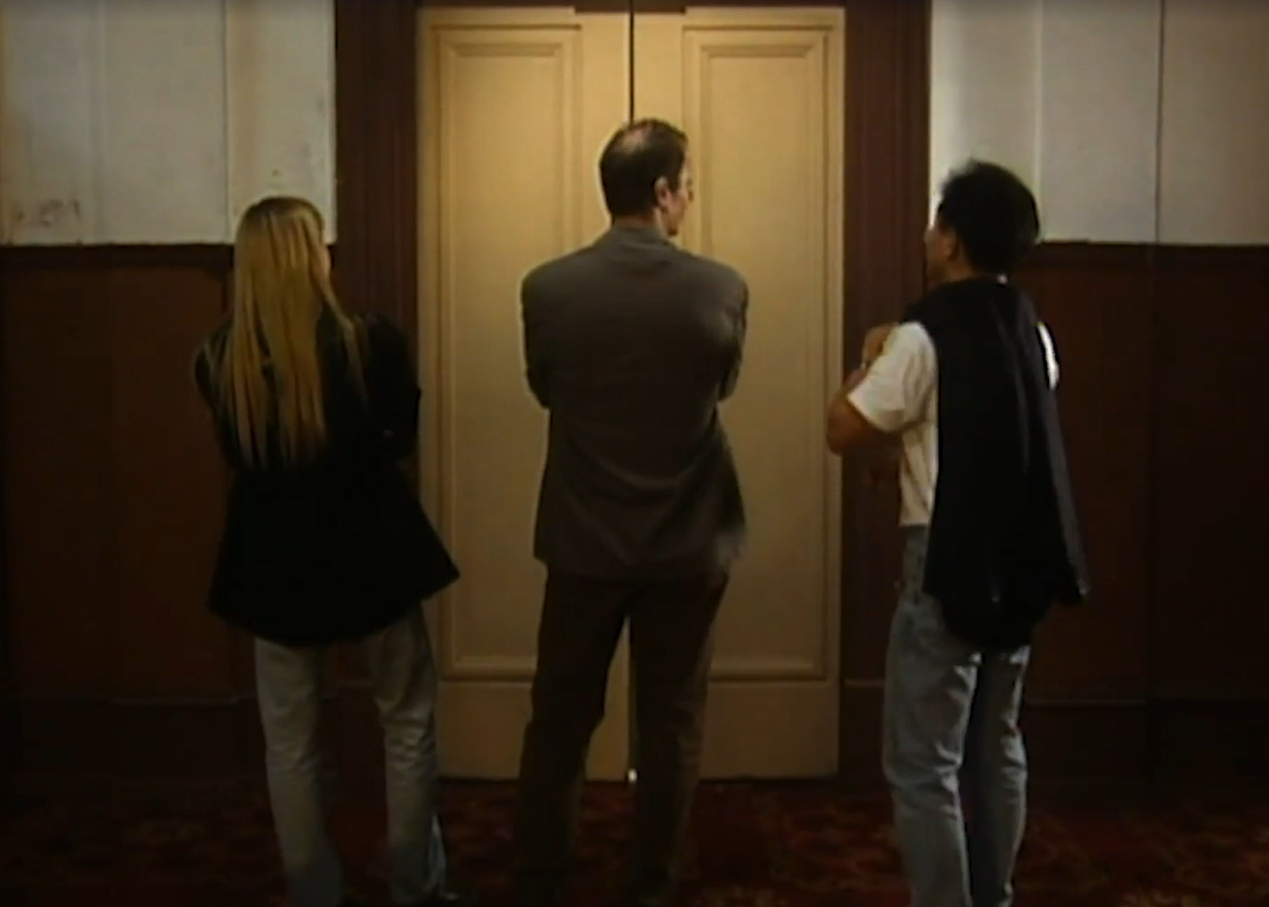 Man and woman and man waiting at elevator